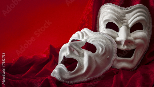 Theatre and opera concept with theatrical masks on red velvet. In Greek mythology Thalia was the Muse of comedy (laughing face), Melpomene was the Muse of tragedy (weeping face) with copy space