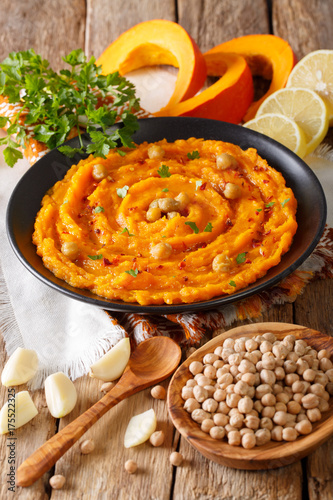 Middle Eastern food: pumpkin hummus with ingredients close-up. vertical