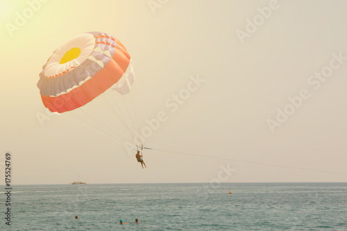 Man is flying on a paraglider over the sea. Toned