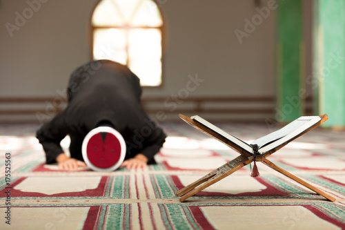 Young Imam praying inside of beautiful mosque