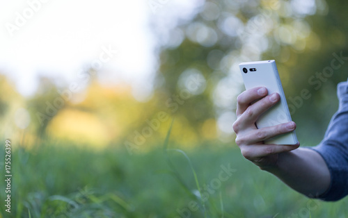 Smartphone in Männerhand, Rückansicht, draußen, Textfreiraum, Breitbild