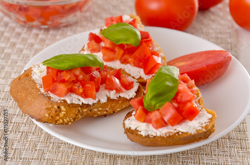 delicious bruschetta with tomatoes on plate on table close-up