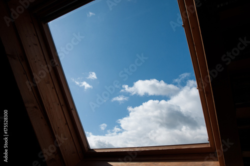 blick durch dachfenster auf freundlichen wolkenhimmel