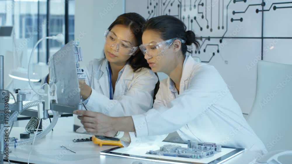 Electronics engineers working in lab building & testing electronic devices Electronics engineers working in lab building & testing electronic devices