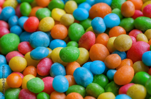 Tasty candy decoration background. Heap of colors candies for children with small green, yellow, blue sweets