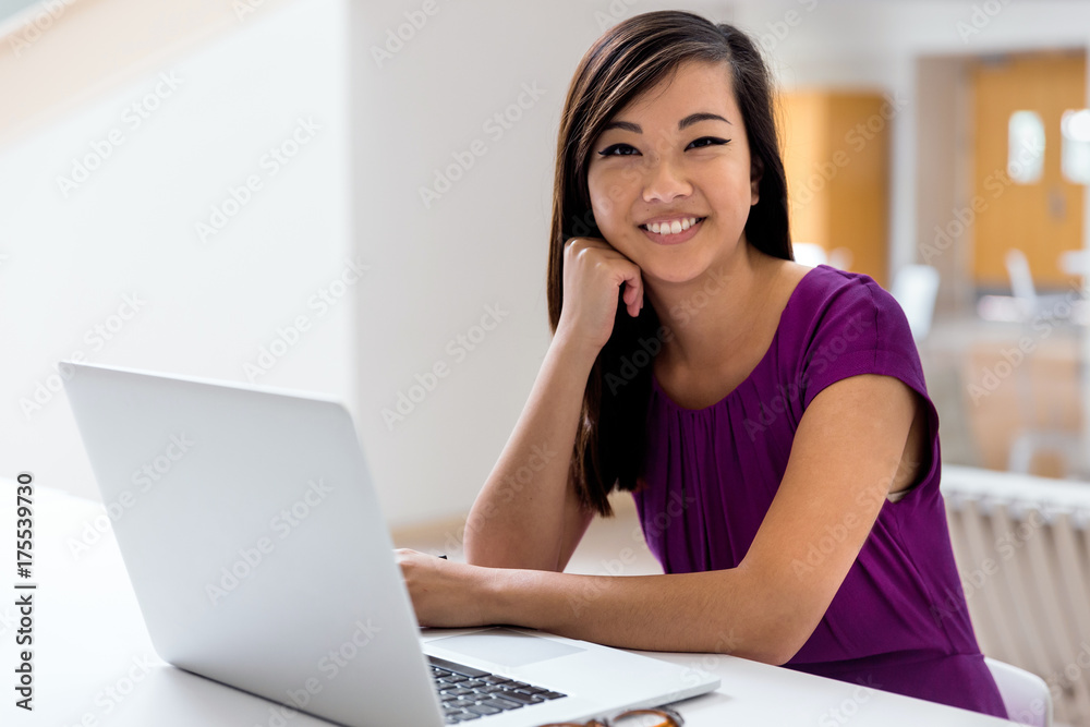 Female student studying on campus from her computer posing for natural portrait Female student studying on campus from her computer posing for natural portrait