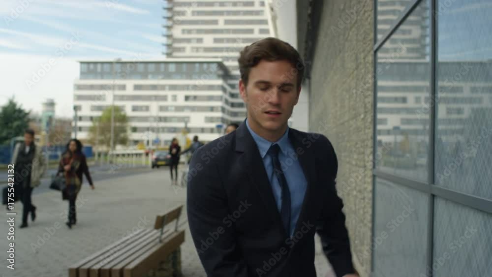 Businessman with bicycle checking his phone as he walks through the city Businessman with bicycle checking his phone as he walks through the city