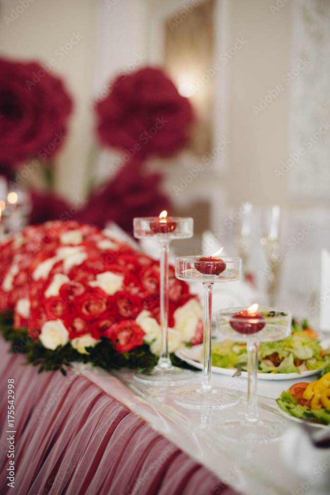 Wedding table decorations flowers, red candles decoration in glases