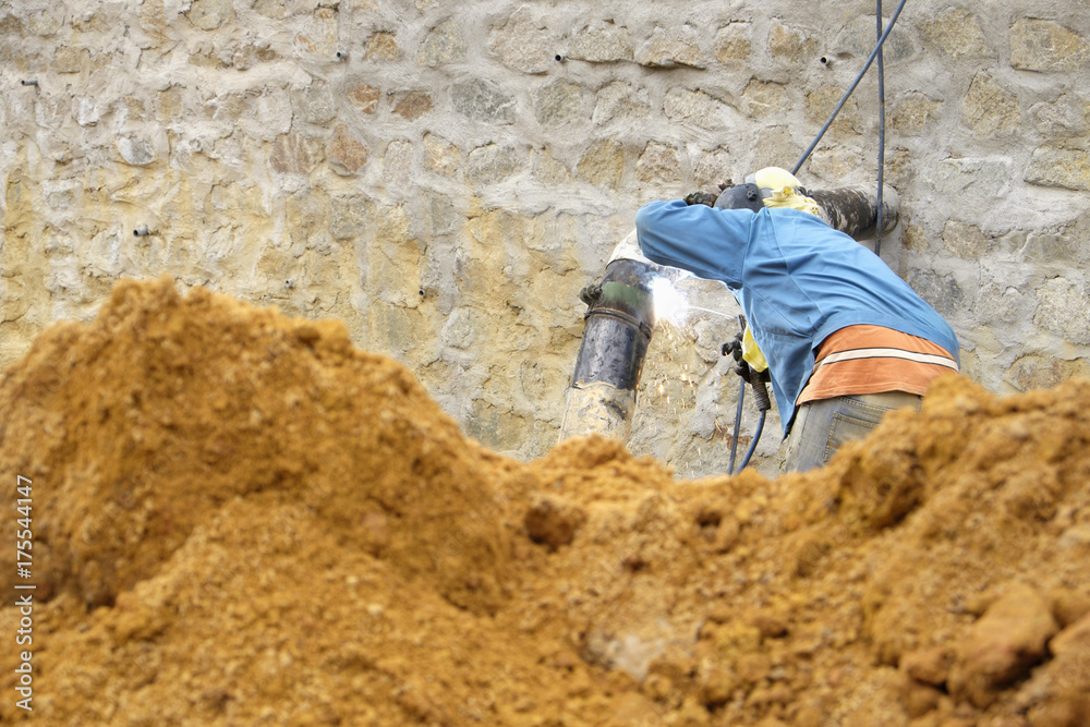 Worker welder pipe arc welding for connection water supply at construction site. Worker welder pipe arc welding for connection water supply at construction site.