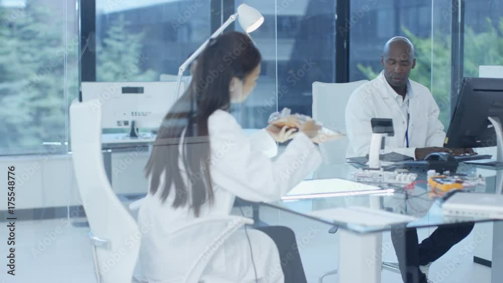 Electronics engineers working in lab, building components with 3D printer Electronics engineers working in lab, building components with 3D printer