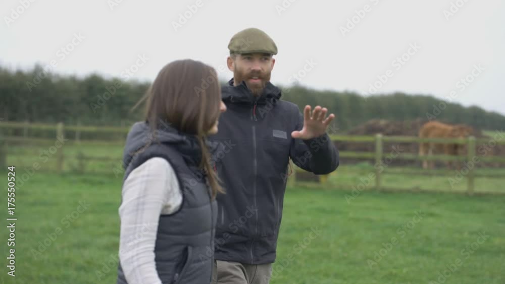 Farming couple walking in the field & checking on the livestock Farming couple walking in the field & checking on the livestock