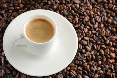 cup of coffee espresso and plate on coffee beans background