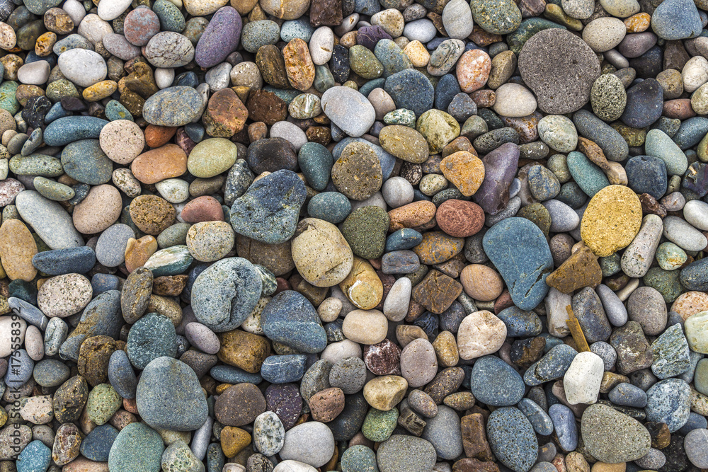 A lot of colored stones on the river bank close-up as background. A lot of colored stones on the river bank close-up as background.
