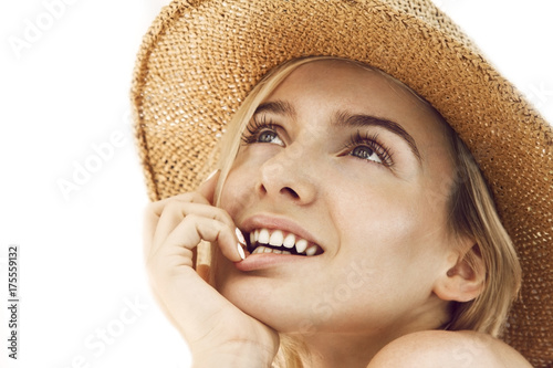 Close up of beautiful young blonde woman with straw hat. 
Professional make-up, hair style and styling.
