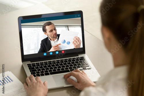 Young businessman shows financial report via video call on laptop screen. Project manager presenting successful investment profit stats to female business partner. Finance success concept. Close up.