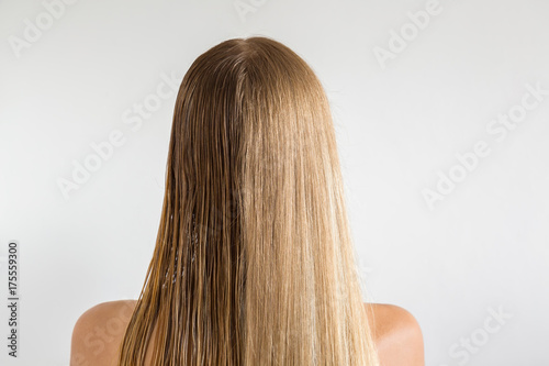Wet and dry woman's blonde hair before and after using hair dryer on the gray background. Cares about a healthy and clean hair. Beauty salon concept.