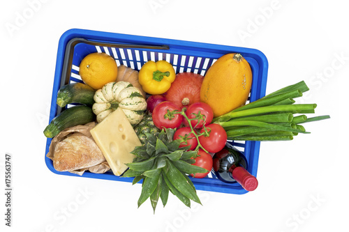 Top view on shopping basket filled with different vegetables and groceries isolated on white background. 