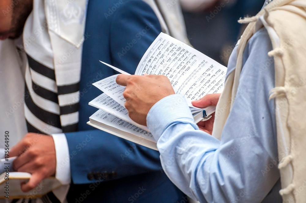 Obraz premium Prayer. The Jewish Hasid reads a religious book. Close-up of a book and hands.