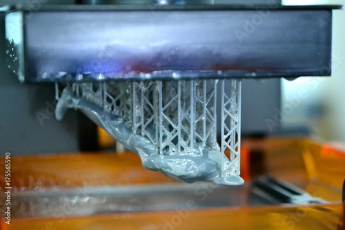 Stereolithography DPL 3d printer create detail and liquid drips, platform slowly move with liquid close-up. Progressive modern additive technology 3D printing, create scaled model by UV polymerization photo
