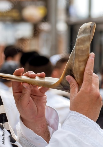 фотографія Jewish hasid blows Shofar. Hands and shofar close-up.
