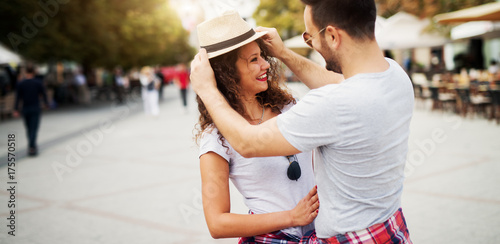 Charming young man putting a hat on a girlfriend in the romantic walk. © dusanpetkovic1
