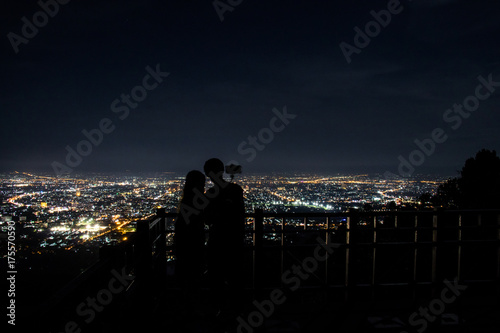 Panorama of the city from the viewpoint with silhouette tourists at Doi Suthep. Chiangmai night view, Thailand.
