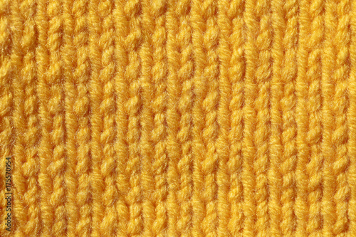Texture of knitted fabric. Background of orange flowers with knitted needle patterns.