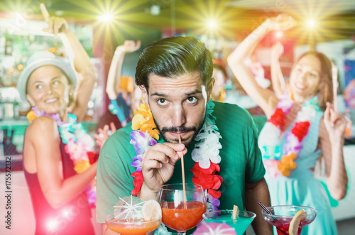 Man is drinking cocktail on hawaiian party