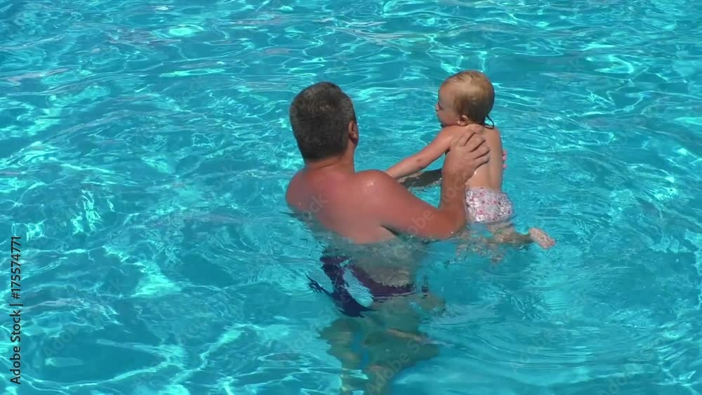 Father with daughter in the pool. Dad teach baby girl to swim Father with daughter in the pool. Dad teach baby girl to swim