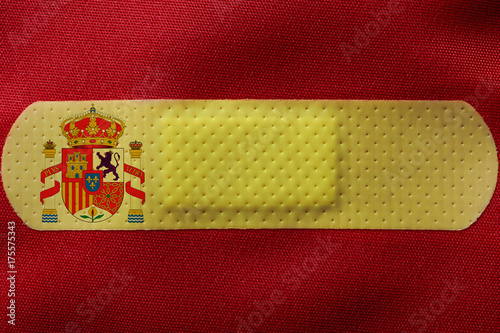 Spain wounded. Spanish flag, with a band aid in its yellow stripe.