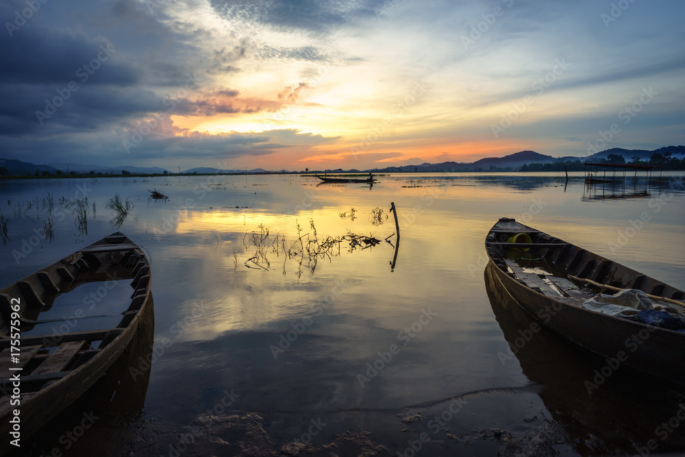Lake with wooden boat at sunset in Vietnam