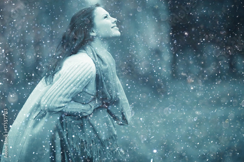Winter portrait of young girl with snowflakes in the air