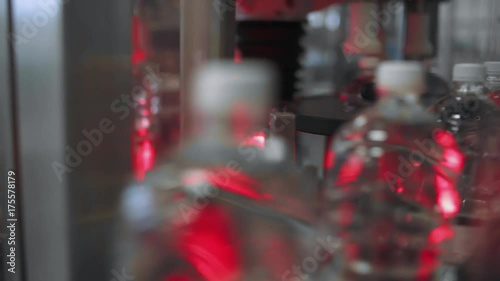 Wallpaper Mural Production line of drinking mineral water and carbonated drinks, plastic bottles moving along a conveyor. Red light.
 Torontodigital.ca