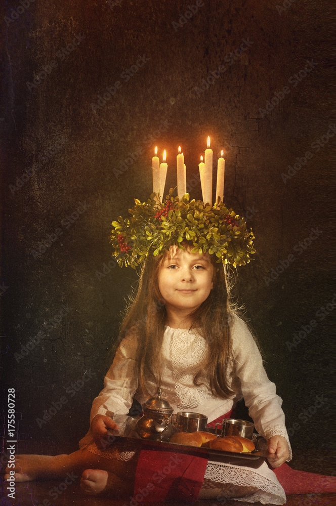 Little caucasian girl in Saint Lucia costume with crown of candles and  traditional swedish sweet Stock Photo | Adobe Stock
