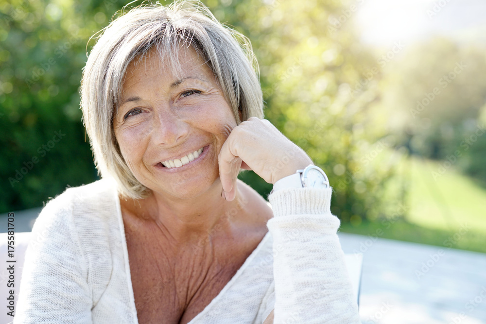 Portrait of cheerful senior woman relaxing in outdoors sofa Portrait of cheerful senior woman relaxing in outdoors sofa
