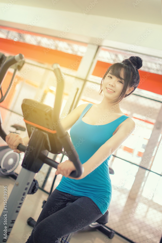 Woman taking break during cycling workout in gym. Female on gym bike doing cardio exercise. Woman taking break during cycling workout in gym. Female on gym bike doing cardio exercise.