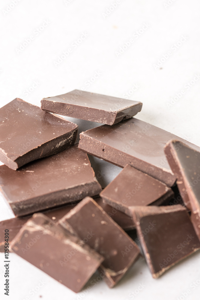 Slices of cooking chocolate on the white marble background table Slices of cooking chocolate on the white marble background table