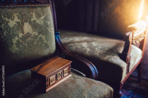 Mysterious wooden music box on the vintage chair. Details of vintage furniture