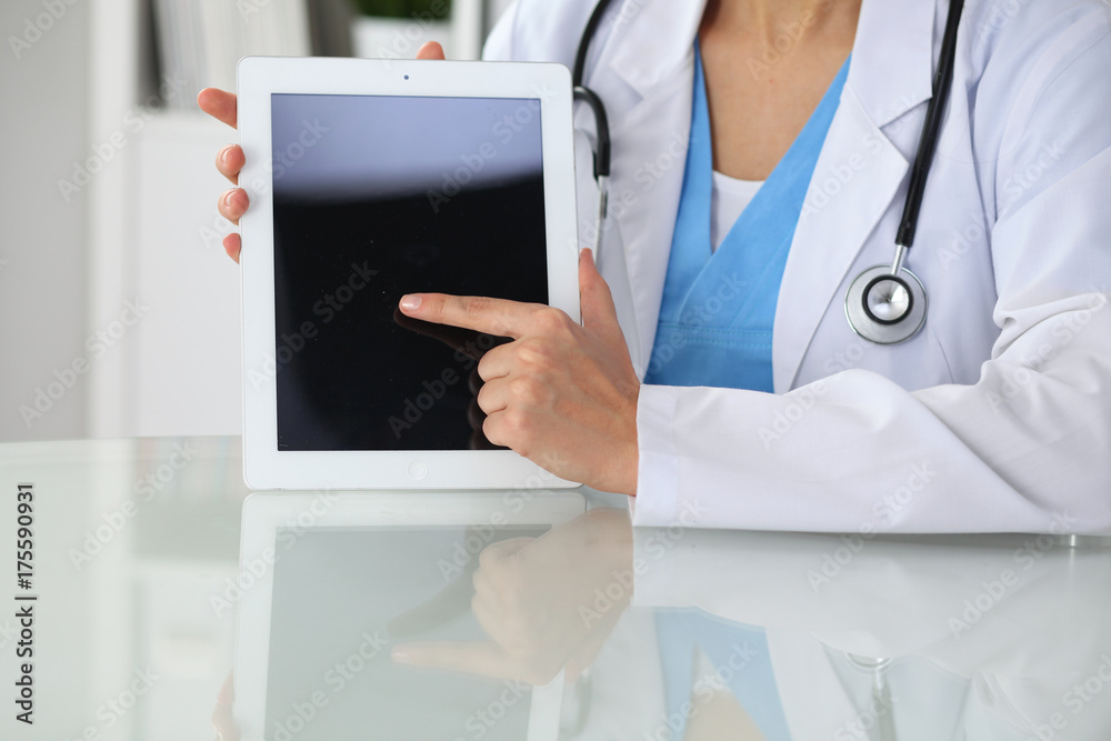 Female doctor pointing into tablet computer, close-up of hands. Physician ready to examine and help patient. Medicine, healthcare and help concept Female doctor pointing into tablet computer, close-up of hands. Physician ready to examine and help patient. Medicine, healthcare and help concept