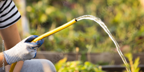Tableau sur toile splashing water from a hose in the garden