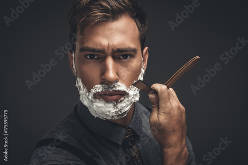 man shaving with straight razor photo