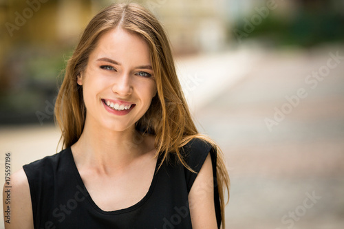 Pretty young lady outdoors. Smilimg woman with nautral beauty posing for camera. photo