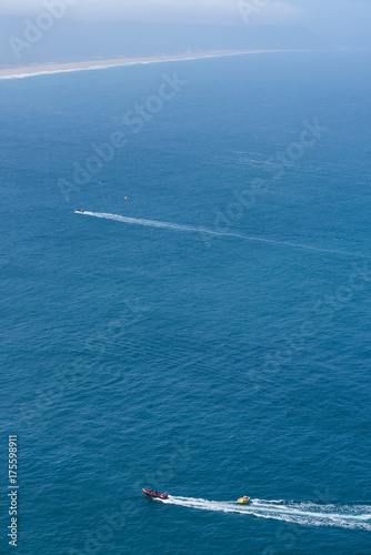 Tourists taking ride by speed boat on rubber tube boat on waves in ocean, birds eye view © nevodka.com