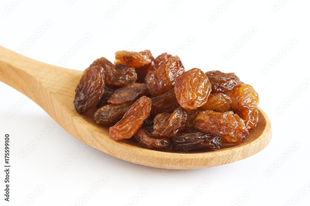 Raw raisins (dried grape) in wooden spoon isolated on white background
