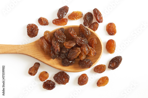 Raw raisins (dried grape) in wooden spoon isolated on white background. Top view photo