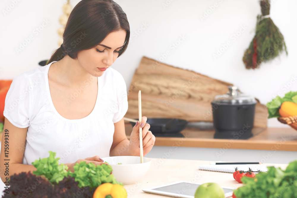 Beautiful Hispanic or latin american woman is holding wooden spoon while cooking in the kitchen. Beautiful Hispanic or latin american woman is holding wooden spoon while cooking in the kitchen.
