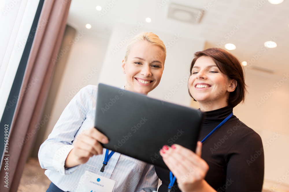 businesswomen with tablet pc and conference badges