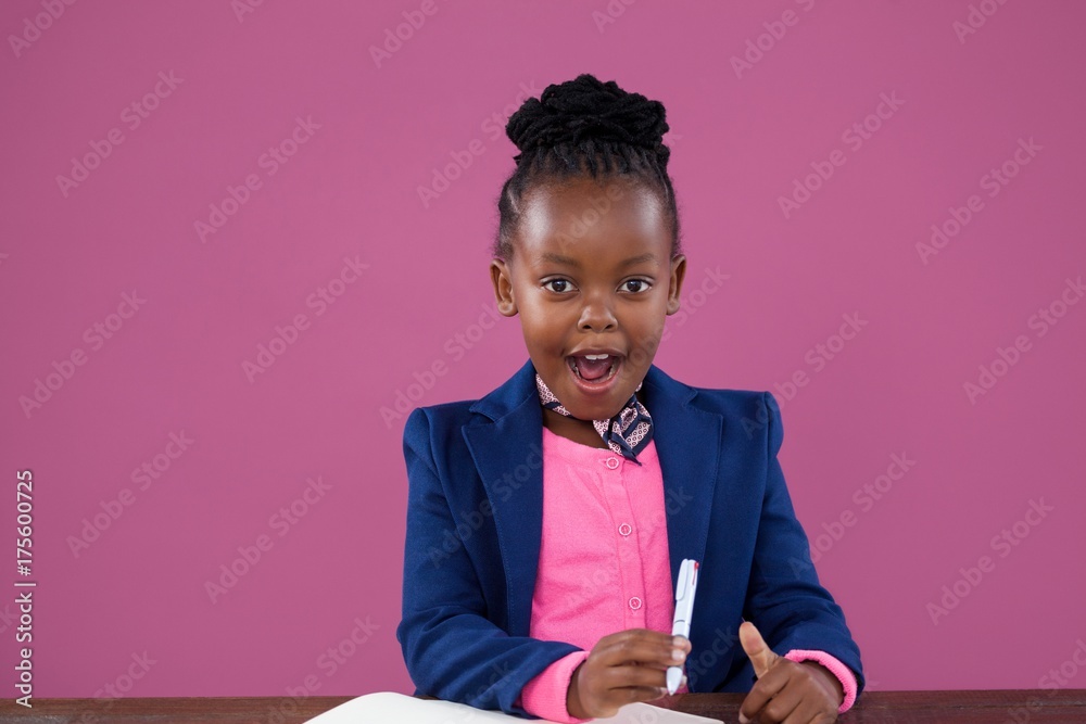 Portrait of surprised businesswoman writing report at desk