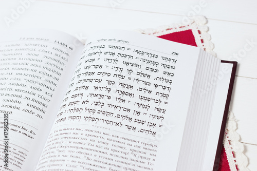 Jewish book on a white background, with red napkin. "Psalms of David". Not isolated image, place for text.Text of the Hebrew, prayer.