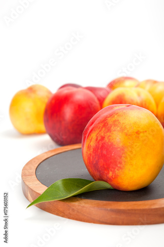 Freshly washed peach  on wooden cutting board isolated on white background